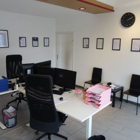 Büro mit zwei Schreibtischen und Zertifikaten an den Wänden